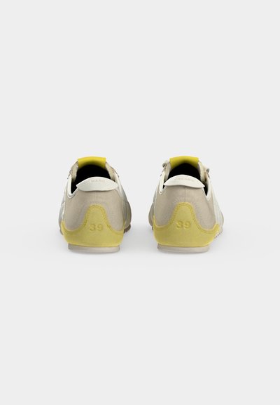 Paire de baskets beige et jaune décontractées vues de dos avec la taille 39 au talon et des languettes blanches.