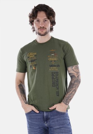 T-shirt in cotone verde oliva con colletto rotondo, caratterizzato da testo e grafiche stampate colorate sul davanti. Maniche corte e vestibilità comoda.