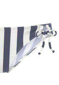 Gestreifte Bikinihose in Marineblau und Weiß. Verfügt über eine Bindedetail an der Seite, mit einem strukturierten Stoff und einem glatten Innenfutter.