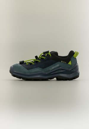 Chaussure de randonnée vert foncé et noire avec des lacets vert vif, une étiquette Gore-Tex et une semelle robuste conçue pour une utilisation en extérieur.
