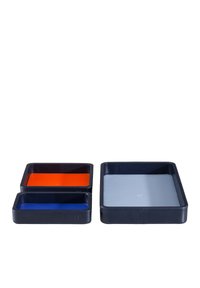 Set of three rectangular trays in dark blue leather with interior colors: one orange, one blue, and one light gray. Smooth texture, sleek design.