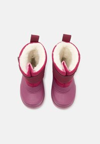 Bottes imperméables roses avec un extérieur lisse, doublure en polaire douce et une sangle Velcro sur le dessus. Tige courte avec un bout arrondi.
