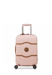 Valise rigide rose avec des accents bruns, finition texturée, poignée télescopique et quatre roulettes. Présente un logo rond au centre.