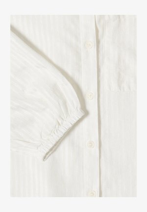 Camicia bianca a maniche lunghe con righe verticali in rilievo, polsino elastico, abbottonatura e taschino sul petto in tessuto liscio.