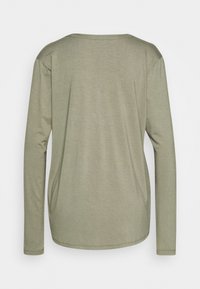 Koszula z długim rękawem w oliwkowym kolorze, wykonana z miękkiego materiału. Posiada okrągły dekolt oraz luźny krój z bocznymi szwami dla dodatkowego wykończenia.