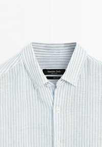 Light blue and white vertical striped linen shirt with button-down collar and white buttons, Massimo Dutti label visible inside collar.