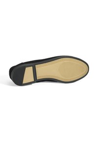 Zwarte schoenzool met een gladde rubberen onderkant, voorzien van een gestructureerd patroon en een contrasterende beige binnenzool. Beide materialen hebben een matte afwerking.