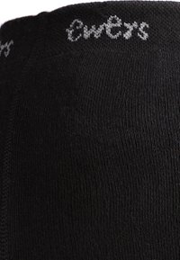 Schwarze Socken aus einem strukturierten Baumwollgemisch, mit einer glatten Oberfläche und einem grauen Markenlogo, das nahe dem oberen Rand gestrickt ist.