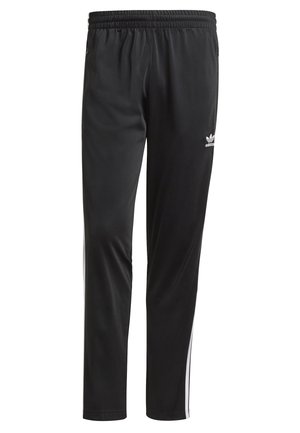 Černé tepláky Adidas s bílými bočními pruhy, elastickým pasem a malým logem trefoil na levé horní stehně.