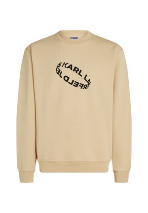 Beige színű pulóver, kerek nyakkivágással. Fekete színű, spirális elrendezésű szöveges mintával rendelkezik. Hosszú ujjú és bordázott szegélyű. 