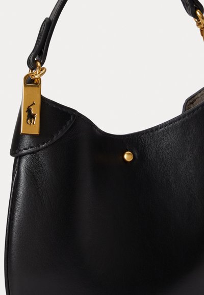 Μαύρη δερμάτινη τσάντα χειρός με καμπυλωτό σχήμα, χρυσά αξεσουάρ και με κόσμημα λογότυπο. Λείο υλικό με γυαλιστερή επιφάνεια.