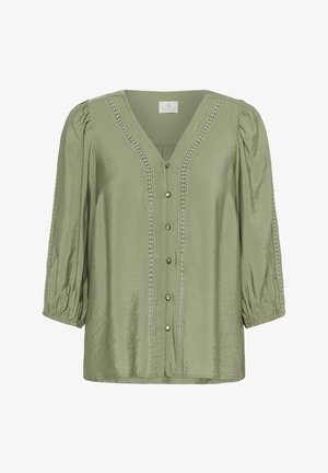 Bluză verde, ușoară, cu decolteu în V, mâneci puff și cusături decorative. Prezintă nasturi asemănători cu perlele pe toată lungimea frontală.