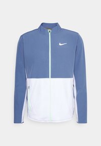 Nike track jacket featuring blue upper, white lower, full zipper, high collar, mesh texture, and a subtle logo on the chest.