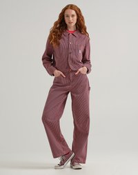 Rot-weiß geringeltes Denim-Jacken- und Hosen-Set mit einer kurzen Jacke, zwei Brusttaschen und weiten Hosen, kombiniert mit grauen Turnschuhen.