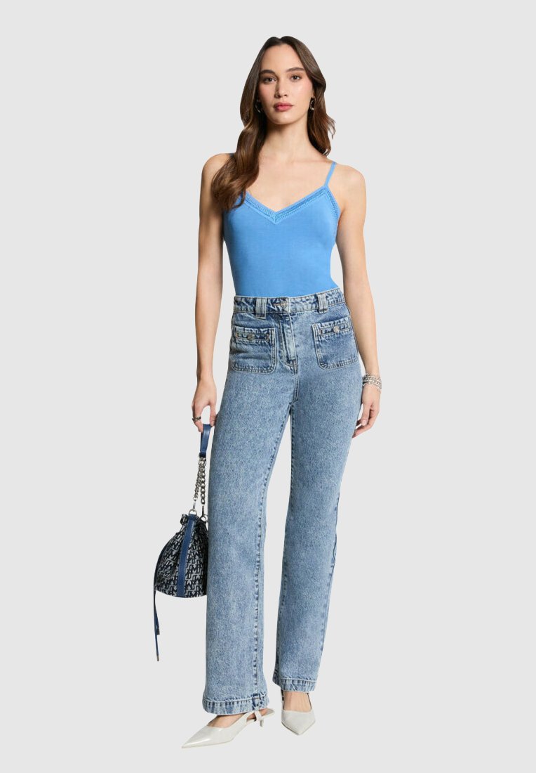 Débardeur ajusté bleu clair avec bord en dentelle, associé à un jean en denim bleu clair taille haute avec de grandes poches avant et des jambes droites.