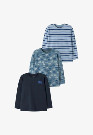 Trois chemises à manches longues pour enfants : une bleu marine avec un logo de camion bleu, une bleue avec de petits motifs de camions et une bleu clair avec des rayures bleu foncé.