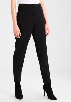 Zwarte op maat gemaakte broek van een gladde stof, met een hoge taille, een platte voorkant en twee zijzakken, gecombineerd met zwarte hoge hakken.