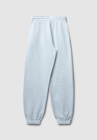 Pantalons de jogging gris clair en tissu doux, dotés d'une taille élastique et de poignets fuselés avec une texture subtile sur l'ensemble.