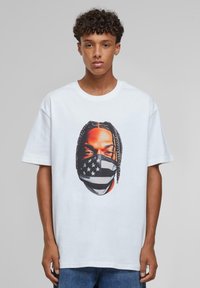 White cotton T-shirt featuring a graphic print of a face in a mask with a black and white American flag design. Short sleeves and relaxed fit.