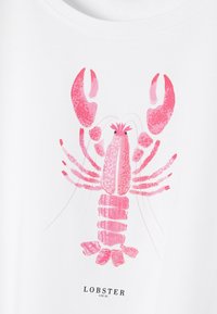 T-shirt blanche avec un graphique de homard dans des nuances de rose, avec de fins détails et une étiquette indiquant "LOBSTER LOCAL" en bas.