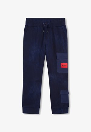 Pantalon de jogging bleu marine avec une taille élastique, un cordon de serrage, deux poches latérales et deux poches cargo sur la jambe droite, dont une avec une étiquette rouge "HUGO".
