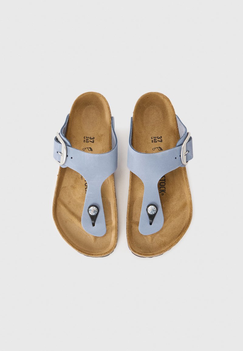 Helles, blaues Paar Sandalen mit glattem Obermaterial, Riemen mit Schnalle und schwarzem Zehensteg, der mit einem dekorativen Kristall versehen ist. Gepolsterte braune Innensohle.