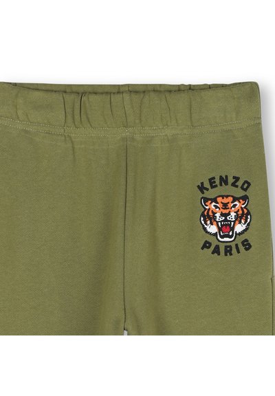 Spodnie dresowe w oliwkowym kolorze z elastycznym paskiem w talii oraz wyszywanym logo tygrysa z napisem "KENZO PARIS" w czerni i pomarańczowym. Miękka tekstura.