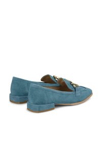 Suède loafers in lichtblauw, met een lage blokhak en decoratieve gouden hardware aan de voorkant. Gladde textuur met een klassiek ontwerp.