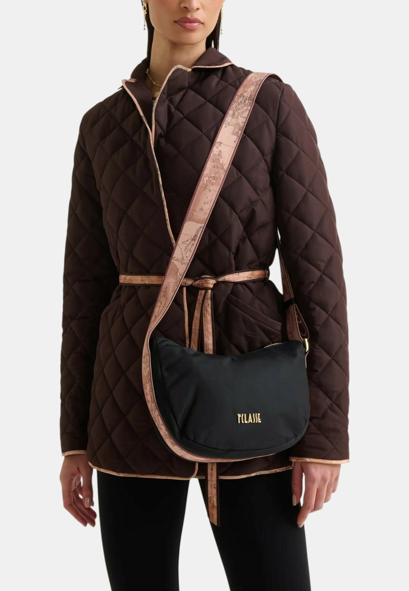 Giubbotto trapuntato marrone con rifiniture rosa chiaro, abbinato a una borsa nera a tracolla con logo dorato e tracolla decorata.