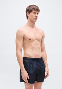 Μαγιό βερμούδα σε ναυτικό μπλε με ελαστική μέση, κορδόνι σκοινί και λείο, ελαφρύ ύφασμα. Διαθέτει άνετη εφαρμογή και απλό σχέδιο.