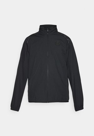 Sort atletisk jakke med ståkrave, fuld lynlås, lange ærmer og et struktureret panel på skuldrene. Har et logo på brystet.
