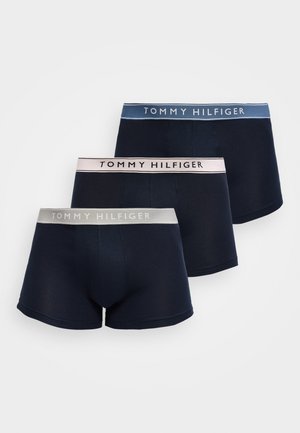 Tri tmavomodré boxerky s kontrastnými elastickými pásmi v sivej, svetloružovej a modrej farbe, z ktorých každý nesie značku „Tommy Hilfiger“.