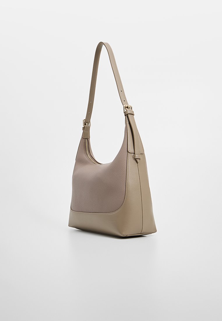 Beige läderhandväska med en strukturerad yta, en slät botten och ett justerbart axelband. Har dragkedjestängning och minimalistisk design.
