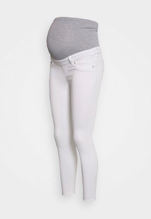 Femme enceinte portant un jean de maternité blanc avec un panneau gris extensible couvrant le ventre, présenté sur un fond blanc uni.