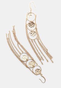 Náušnice v zlatej farbe so skladajúcimi sa tromi vyrazenými kruhovými akcentmi, s kaskádovými reťazcami pre pridanie textúry a dĺžky. Zapínanie na háčik.