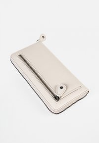 Lichtbeige leren portemonnee met een ritsluiting en een externe ritsvak. Voorzien van twee zwarte drukknoopjes en contrasterende stiksels.