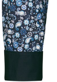 Indumento a maniche lunghe realizzato in un tessuto blu navy con intricate fantasie floreali e paisley bianche e blu. Polsino nero solido all'orlo.