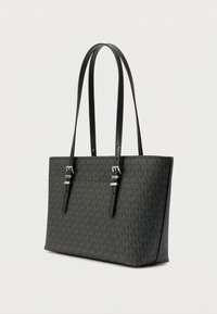 Mala tote preta com padrão texturizado. Apresenta duas alças longas e detalhes em metal prateado. Forma retangular, design estruturado.