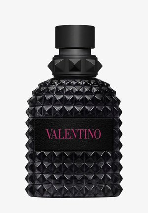 Flacon de parfum en verre noir clouté avec un bouchon cylindrique et une étiquette noire portant la mention "VALENTINO" en lettres rouges.