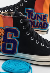Hohe Sneakers aus schwarzem Canvas mit bunten Akzenten; mit "Tune Squad"- und Nummer-6-Patches. Enthält blaue Schnürsenkel.