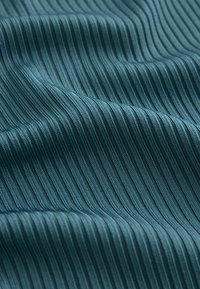 Textuurstof in teal met een verticale ribbelpatroon, die een zachte, gladde textuur en een subtiele glans toont.