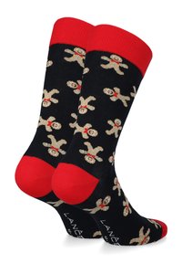 Czarne skarpetki z czerwonym ściągaczem mają wzór w postaci piernikowego ludka w kolorze beżowym i czerwonym, wykonane z mieszanki bawełny, o miękkiej fakturze i dopasowanym kształcie.