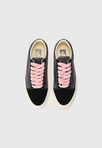Black and gray canvas sneakers with a suede toe cap, pink laces, white stitching, and a cream rubber sole, featuring a logo on the insole.