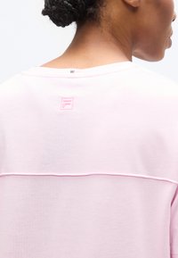 Ροζ κοντομάνικο πουκάμισο με στρογγυλή λαιμόκοψη, ραφή στην πλάτη και μικρό κεντημένο λογότυπο σε αντίθετη ροζ απόχρωση. Λείο ύφασμα.