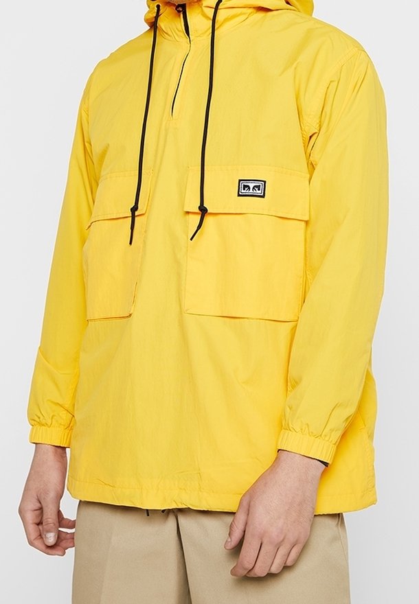 Yellow lightweight pullover jacket with a hood, two front pockets, adjustable drawstring, and elastic cuffs. Smooth texture and water-resistant.