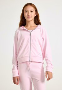 Różowa bluza z kapturem na zamek, uszyta z miękkiego materiału, z kieszeniami z przodu i elastycznymi mankietami. Połączona z dopasowanymi różowymi dresami z troczkami.