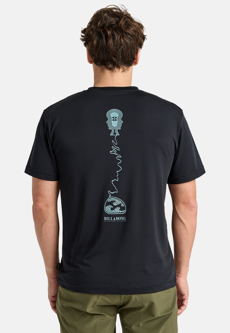 Camiseta negra de manga corta con un diseño gráfico turquesa de caras abstractas y un globo en la parte posterior, fabricada con un material transpirable.