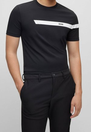 Czarny T-shirt z krótkim rękawem z białym poziomym paskiem z napisem "BOSS". Dopasowany krój, wykonany z gładkiej tkaniny.