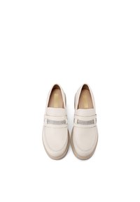 Mocassini in pelle beige con un accento argento sulla parte anteriore. Punta arrotondata e texture sottile, su suola in gomma di colore chiaro.