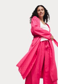 Robe in stile kimono rosa con pantaloni a gamba larga abbinati. Tessuto morbido con un sottile motivo a pois, dotato di vita legata e maniche ampie.